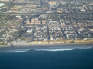 Aerial view of part of old town Encinitas showing Moonlight Beach on the left. Parallel with the shore is Historic Coast Highway 101, also parallel and further inland is Interstate 5