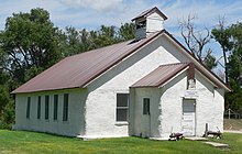 One-story building with peaked roof, small steeple