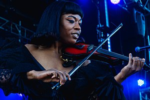 Brittney Denise Parks wearing a black top, playing violin onstage