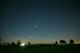 Night sky with a very bright satellite flare