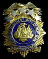 A modified version of the shield and supporters on the badge of the city police commissioner