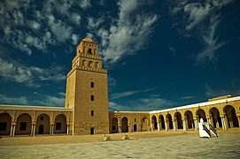 Vue de la cour et du minaret à trois étages dégressifs superposés.