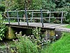 De brug over de wegsloot bestaat uit twee betonnen landhoofden die over de sloot met elkaar zijn verbonden door een samenstelsel van houten planken. Hierop zijn aan de buitenzijden onder een schuine hoek twee relingen geplaatst, opgebouwd uit houten stijlen en twee rijen ijzeren regels