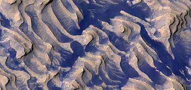 Close, color view of layers and dark dust on floor of Danielson Crater, as seen by HiRISE under HiWish program Boulders are visible in the image.