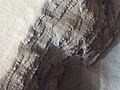 Straturile din multe fluxuri de lavă sunt vizibile într-o groapă din flancul inferior de vest al Arsiei Mons (foto de HiRISE).