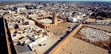 Photographie montrant une vue aérienne de la Grande Mosquée de Kairouan. Celle-ci est située à l'extrémité nord-est de la médina, à proximité des remparts dont elle n'est séparée que par une esplanade.