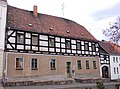 Wohnhaus in geschlossener Bebauung, seitlich überbaute Tordurchfahrt und Seitengebäude eines Ackerbügerhofes