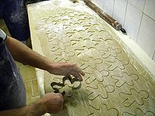 a large amount of cookie dough has been rolled out and is being cut into cookies