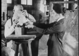 A woman adjusting the mounting of a Greek sculpted head on a stand.