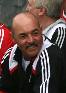 Portrait de Bruce Grobbelaar en survêtement dans les tribunes d'un stade de football à l'occasion d'un match de gala en 2008.