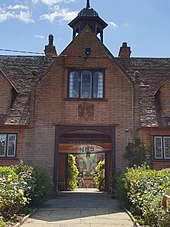 View through the central archway towards the quadrangle and the sundial. Sidney Hill's coat of arms is shown over the archway.