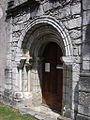 Portail de l'église Notre-Dame de Luzenac-de-Moulis. Le portail possède deux archivoltes reposant sur des chapiteaux ornés de palmettes et de visages humains.
