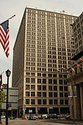 A squarish brown building is at a street corner.