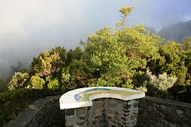 Une table d'orientation face à un paysage ennuagé des Hauts de La Réunion, France.