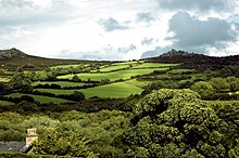 Green hills with trees in the foreground.