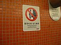 「嚴禁吐痰 免生細菌」的告示已換上「違反港鐵附例罰款港幣5,000元」字樣，上面貼有小小的港鐵貼紙，遮掩著地鐵的標誌。