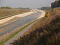 Blick auf das leere Kanal­bett von der Brücke bei Vinnum aus nach Norden, im Hinter­grund ist die Tunnel­bau­stelle der Unter­führung B236 Olfen-Selm zu sehen.