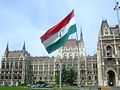 Hungarian revolution flag in front of the Hungarian Parliament Building