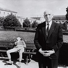 André Maurois auf einer undatierten Schwarzweißaufnahme, im Münchner Hofgarten, Schlafender auf Parkbank im Hintergrund