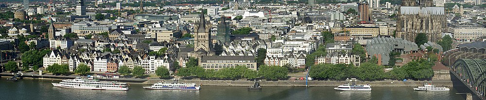 Panorama centra Kolína nad Rýnem. Ve středu obrázku je kostel Groß St. Martin, vpravo budova Kolínské filharmonie a Museum Ludwig, zcela vpravo Hohenzollernbrücke (Most Hohenzollernů) se vjezdem do Kolínského hlavního nádraží v červenci 2006.