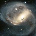 NGC 7319; strzałka wskazuje prześwitujący przez galaktykę kwazar