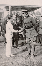 le roi en uniforme serre la main d'un sportif