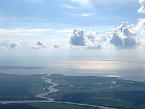 Pirmame plane - iš kairės atitekanti Rusnės upė, ties Rusnės miesteliu skylanti į dvi šakas: Atmatą (pirmame plane, toliau teka į dešinę) ir Skirvytę (vingiuotai teka į tolumoj mėlynuojančias Kuršių marias). Skirvytės kairysis krantas priklauso Rusijos Federacijos Kaliningrado sričiai.