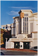 Vue de l'entrée d'un musée ; façade en verre sur plusieurs étages.