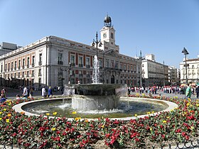 Puerta del Sol plazako iturria eta Errege Postetxea.