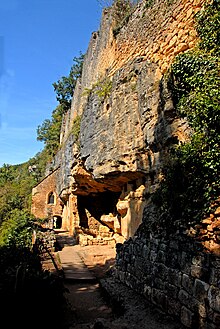 Una grotta di pietra ocra che ospita uno scavo archeologico