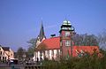 St.-Willehadi-kerk met toren[2], de namaakkoe op het kerkdak herinnert aan de vroegere grote veemarkt