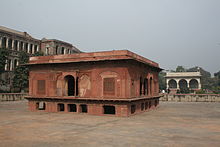 Square red sandstone building in a dried-out water tank