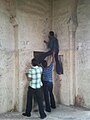 Oamenii mâzgălind pereții Fortului Golconda din Hyderabad, India