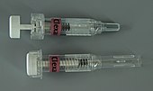 Fertigspritzen; vor der Anwendung mit Schutzkappe (oben), entleerte Spritze mit aktiviertem Kanülensicherungsmechanismus (unten)