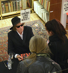 Öijer signs his poetry collection at an antiquarian in Stockholm