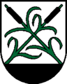 Wappen der oberösterreichischen Gemeinde Moosdorf. Blasonierung: „Aus schwarzem Schildfuß wachsend in Silber zwei gekreuzte grüne Schilfrohre (sic!) mit grünen Blättern und schwarzen Kolben.“