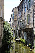 Photographie du canal des usines entre deux immeubles.