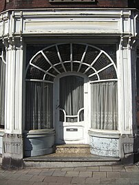 Place du Chenois. Maison du début du XXe siècle ayant conservé une belle devanture et une façade de style Art nouveau[23].