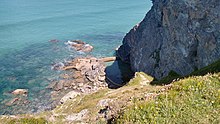 Photo showing a view down Eastcliff down towards the sea and the tidal pool in the rocks.