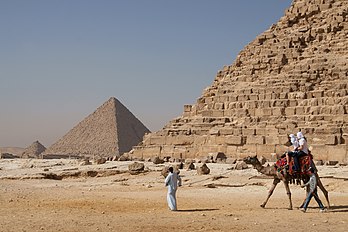 Touristes montant un chameau de Bactriane (Camelus bactrianus) devant la pyramide de Khéphren. La pyramide de Mykérinos est en arrière-plan. (définition réelle 3 300 × 2 200)