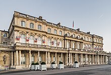 Photographie de la façade du Palais du Gouvernement donnant sur la place de la Carrière sur un ciel bleu.