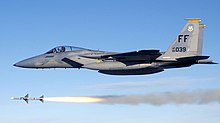 Gray jet aircraft flying above missile following firing of the weapon.