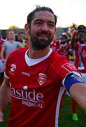 Photographie du visage de Benoît Poulain portant le maillot du Nîmes Olympique.