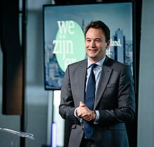 Smiling middle-aged Caucasian male in a suite standing indoors