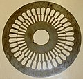 Utstanset stålplate for henholdsvis rotor (senter) og stator (periferi). De utstikkende delene av stålprofilene kalles tenner.