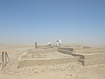 People looking at ruins in a desert