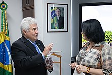 A man and a woman in business attire in an office-like setting