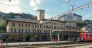 Wide four-story building with hip roof and clock tower