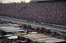 An view of Martinsville Speedway with trucks in the infield and spectators in the grandstands in the outfield