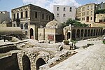 Ruins of underground buildings and a building with cuppola above ground.